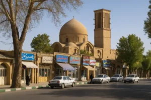 نمایی از محله بروجردی در ایران، با معماری سنتی آجری شامل گنبد و بادگیر، مغازههای قدیمی با تابلوهای رنگی، درختان کنار خیابان و خودروهایی که در خیابان پارک شدهاند، در یک روز آفتابی.
