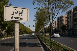 نمایی از خیابان ابوذر تهران در روزی آفتابی، با درختان سبز در حاشیه، ساختمانهای مسکونی چند طبقه، و تابلوی راهنمایی که نام محله «ابوذر» را نشان میدهد.