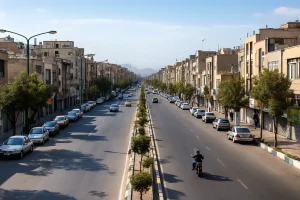 «خیابان عریض یافتآباد شمالی با ساختمانهای مسکونی، درختان وسط بلوار و خودروهای پارکشده.»